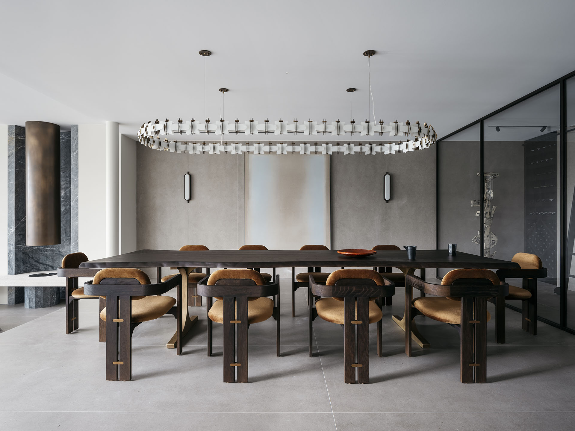 A spacious dining room with a large rectangular table, custom chairs, and a unique chandelier, all designed by Nina Maya Interiors to complement the minimalist aesthetic.