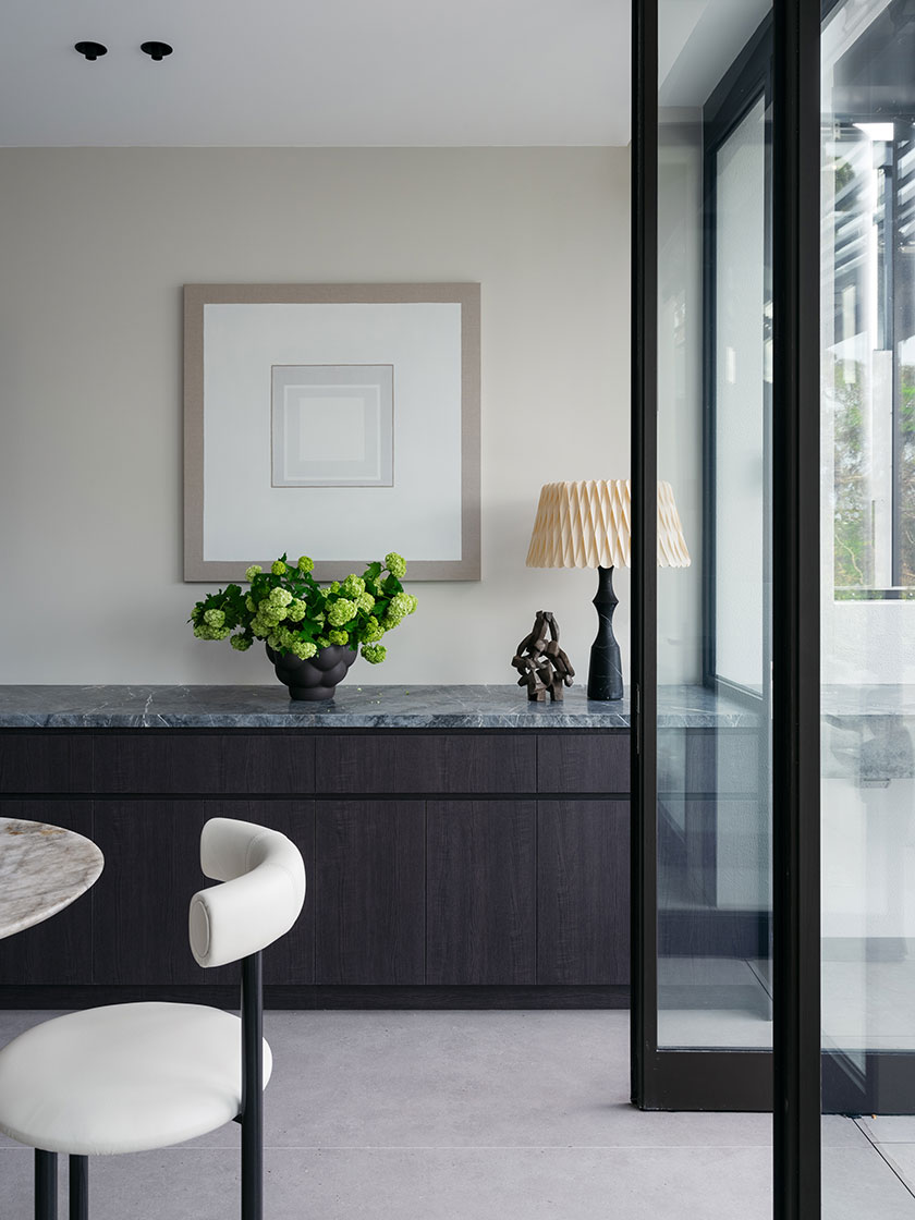 Close-up view of the same living area, showcasing the detailed texture of the white tufted armchairs and the three colorful nested side tables with round tops.