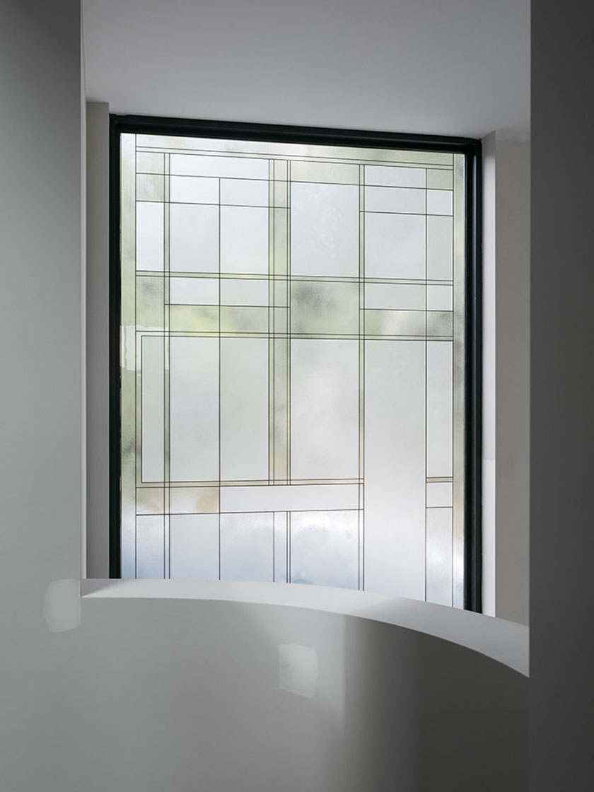 Modern window design by Nina Maya Interiors, featuring frosted glass panels with geometric patterns.