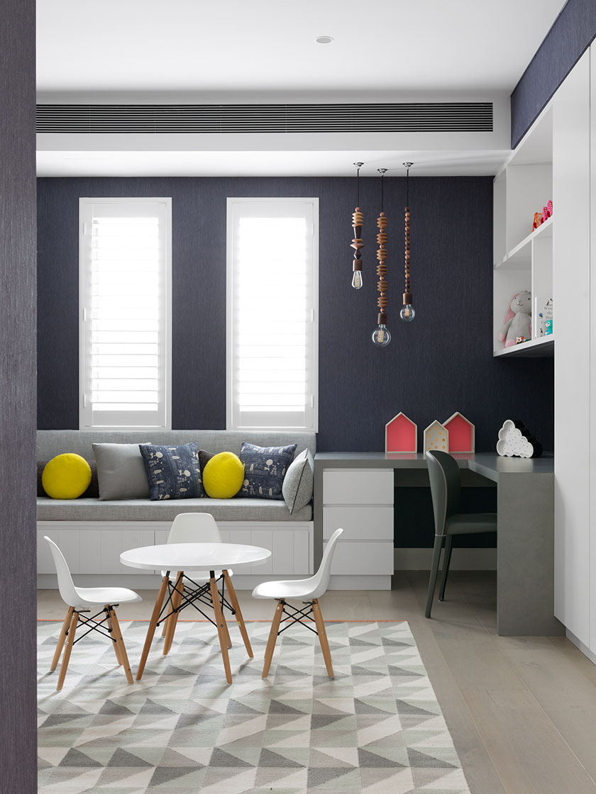 Bright playroom with a built-in bench, white furniture, and colorful decor, designed by Nina Maya Interiors.